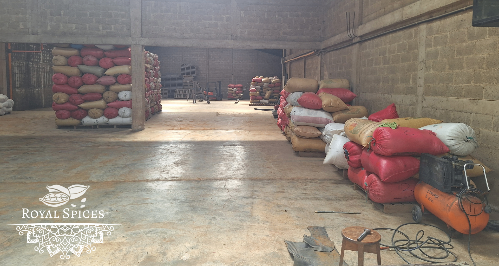 Wide warehouse view with stacked Royal Spices lots